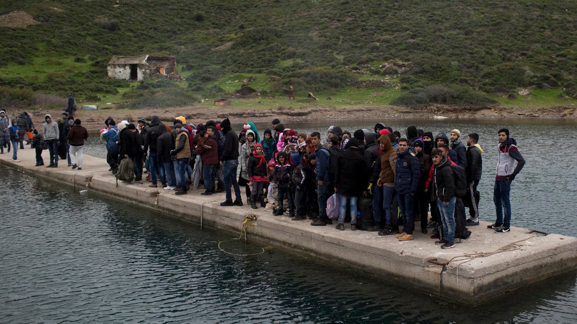 In this Wednesday, Jan. 20, 2016 photo, refugees and migrants who have arrived from Turkey wait for the Greek coast guard. (AP)