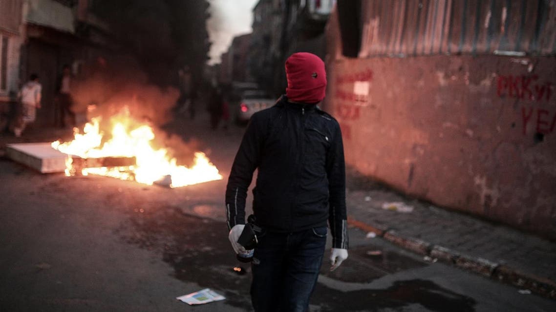 A masked man prepares to throw a petrol bomb toward police who use water cannons and teargas to disperse people protesting against security operations against Kurdish rebels in southeastern Turkey. (AP)