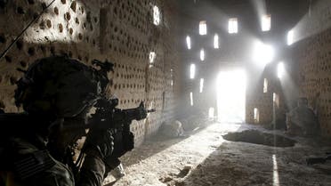 U.S. soldier Nicholas Dickhut from 5-20 infantry Regiment attached to 82nd Airborne points his rifle at a doorway after coming under fire by the Taliban while on patrol in Zharay district in Kandahar province, southern Afghanistan in this April 26, 2012 file photo. (Reuters)