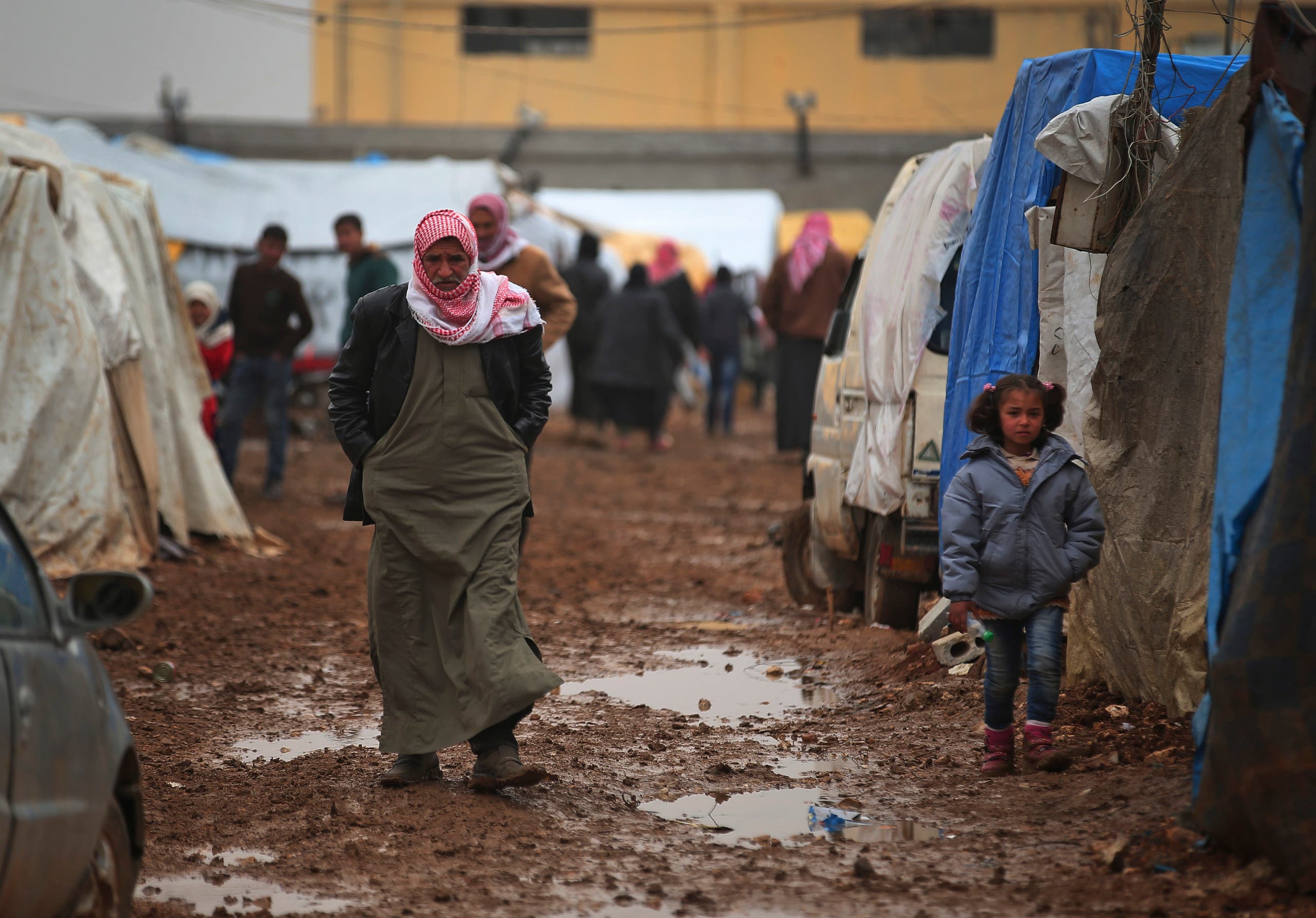  Syrian walk at a camp near the Bab al-Salam border crossing with Turkey, in Syria, Saturday, Feb. 6, 2016. Thousands of Syrians have rushed toward the Turkish border, fleeing fierce Syrian government offensives and intense Russian airstrikes. Turkey has promised humanitarian help for the displaced civilians, including food and shelter, but it did not say whether it would let them cross into the country. (AP Photo/Bunyamin Aygun) TURKEY OUT