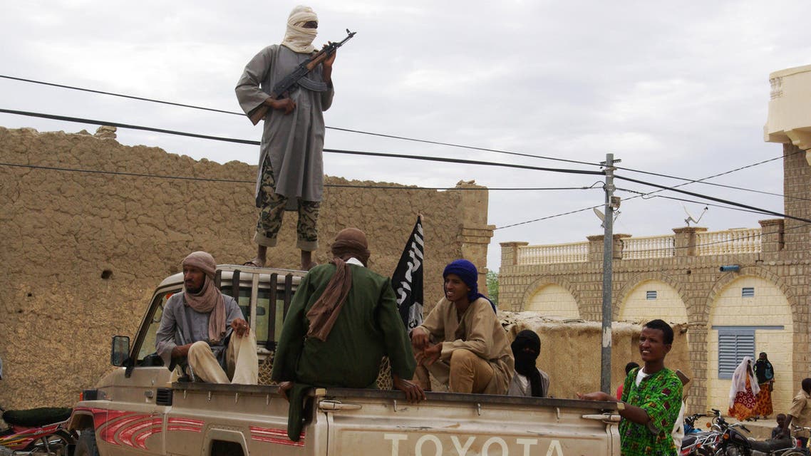 In this Aug. 31, 2012 file photo, fighters from the al-Qaida-linked Islamist group Ansar Dine stand guard in Timbuktu, Mali, as they prepare to publicly lash a member of the Islamic Police found guilty of adultery. (AP)