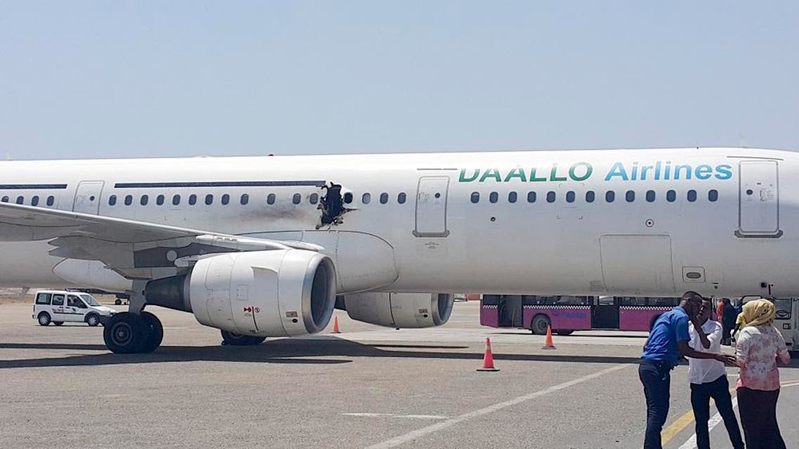 In this photo taken Tuesday, Feb. 2, 2016, a hole is seen in a plane operated by Daallo Airlines as it sits on the runway of the airport in Mogadishu, Somalia. A gaping hole in the commercial airliner forced it to make an emergency landing at Mogadishu's international airport late Tuesday officials and witnesses said. (AP Photo)