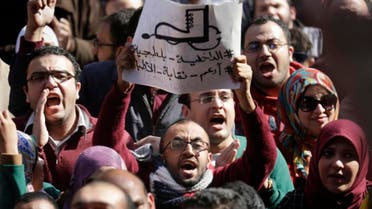 Egyptian doctors shout anti-police slogans as one holds a banner showing a police boot stepping on a medical stethoscope with Arabic slogan reading, "police are thugs." (AP) 