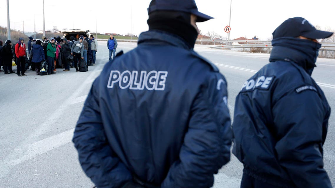 Refugees and migrants embark in a police van as policemen patrol on a highway near the northeastern Greek village of Thourio, at the Greek-Turkish border on Sunday, Jan. 24, 2016. (aP)