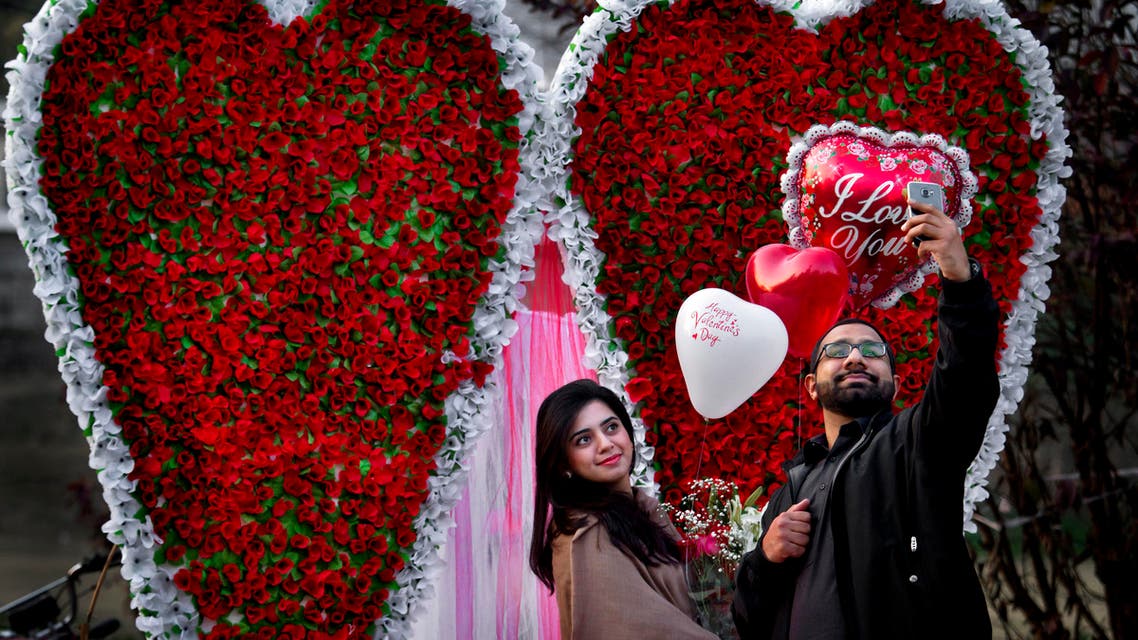 A couple take 'selfie' in front of a giant heart-shaped bouquet display by a vendor to attract customers on Valentine's Day, Sunday, Feb. 14, 2016. (AP)