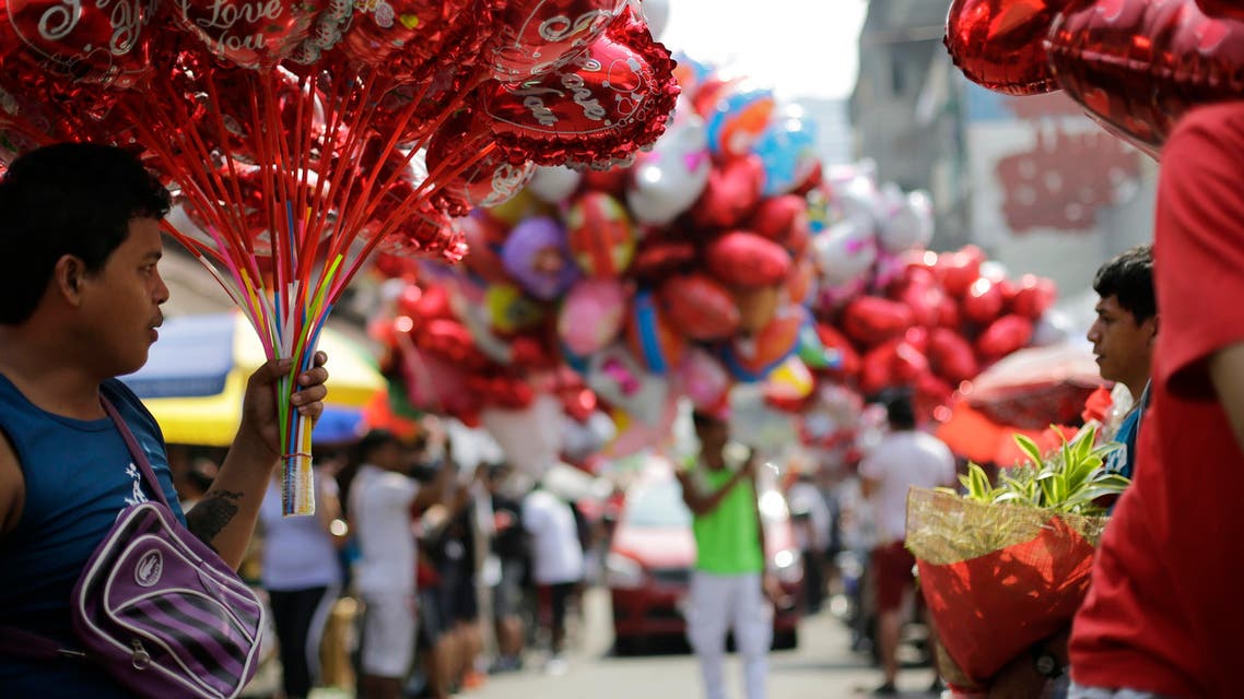 A Filipino sells hear-shaped balloons at a flower market in Manila, Philippines on Valentine's Day, Sunday, Feb. 14, 2016. (AP)