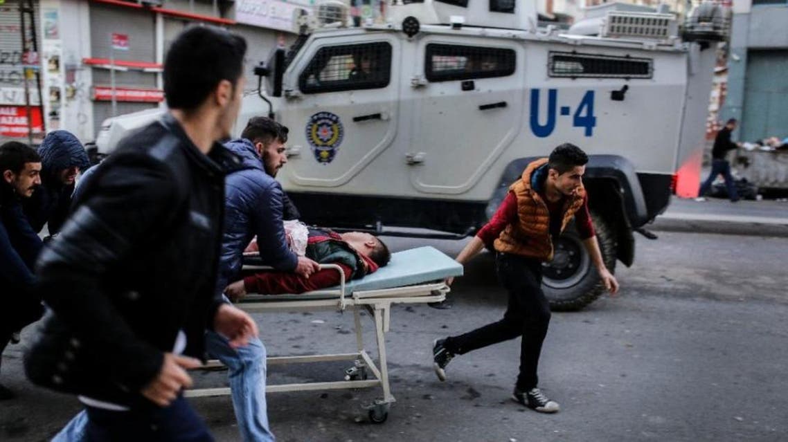 An injured protestor is carried by others during clashes between Turkish protestors and police as they demonstrate against curfews in eastern Turkey on February 14, 2016, in Istanbul (AFP)