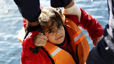 Greek Coast Guard officers move a girl from a dinghy carrying refugees and migrants aboard the Ayios Efstratios Coast Guard vessel, during a rescue operation at open sea between the Turkish coast and the Greek island of Lesbos, February 8, 2016. AP