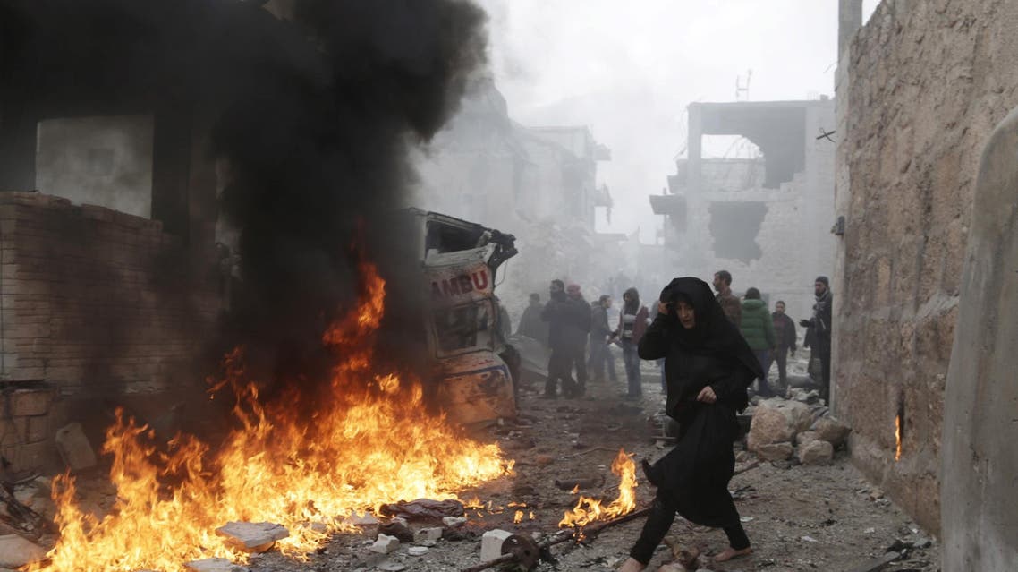 A woman walks past dead men amidst debris at a site hit by what activists said were three consecutive air strikes carried out by the Russian air force, the last which hit an ambulance, in the rebel-controlled area of Maaret al-Numan town in Idlib province, Syria January 12, 2016. (Reuters)