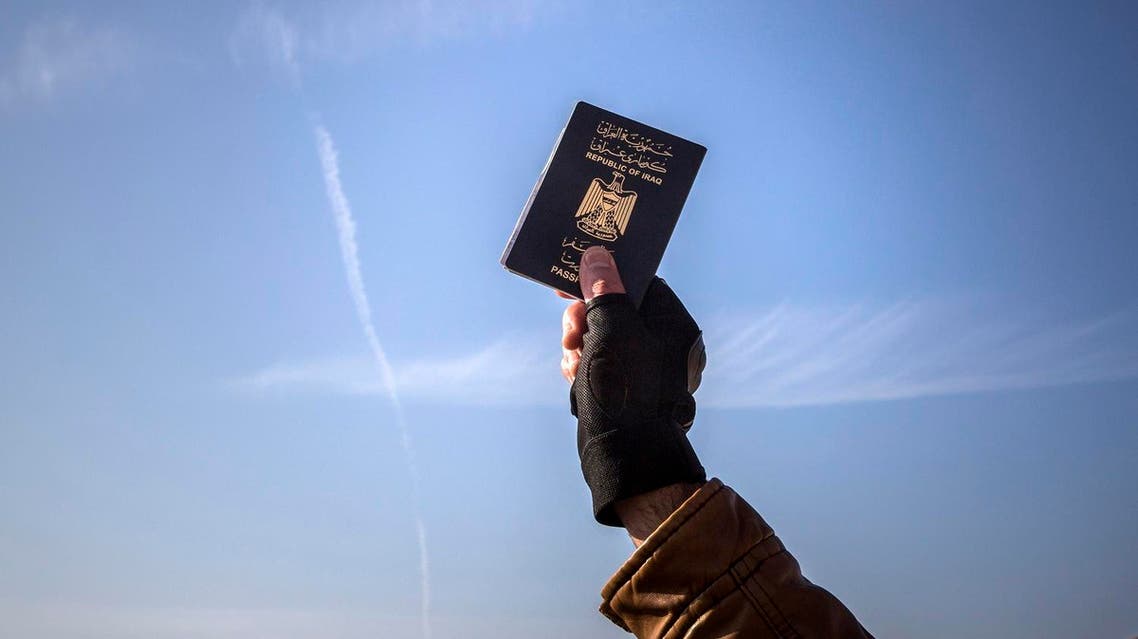 A refugee holds up his Iraqi passport at the port of Molyvos after a rescue operation by members of the Frontex, European Border Protection Agency, from Portugal near the northeastern Greek island of Lesbos. (File photo: AP)