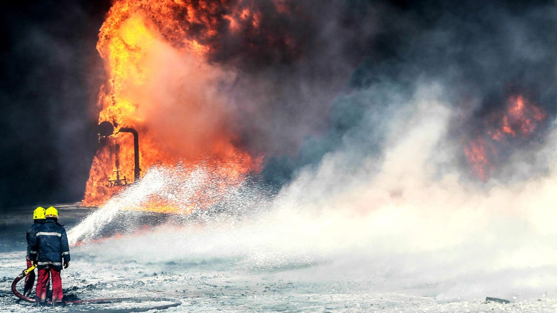Firefighters try to put out the fire in an oil tank in the port of Es Sider, in Ras Lanuf, Libya, believed to be caused by ISIS - January 6, 2016. (Reuters)