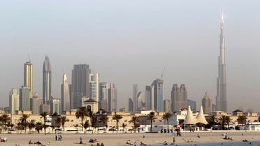 In this photo dated Thursday, July 26, 2012, people enjoy swimming at Jumeirah open beach with the city skyline in background, Dubai, United Arab Emirates. Not all Dubai beaches are hidden behind high-end hotels and waterfront palaces. Jumeirah Open Beach is one of the city's most popular, drawing everyone from Russian tourists and Arab families to Indian and Pakistani migrant workers relaxing on their day off. One you've had your fill of the white sand beach and sparkling Gulf waters, turn around to take in the view of Dubai's futuristic skyline. Facilities include showers and a rare cycle path. The nearby Jumeirah Beach Park offers more greenery and less ogling, but the upgrade comes with a 5 dirham ($1.36) entry fee. (AP Photo/Kamran Jebreili)