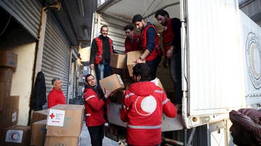 Red Crescent members unload aid boxes in the rebel held besieged city of Douma, a suburb of Damascus February 13, 2016. REUTERS
