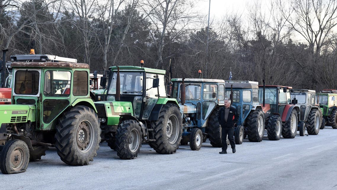 A protesting farmer walks next to parked tractors during a blockade in the northern Greek village of Promahonas village at the customs of the Greek-Bulgarian borderline on Monday, Jan. 25, 2016. Greek farmers angry at planned pension and tax reforms have expanded their campaign of blocking highways and closed a border crossing to Bulgaria, leaving dozens of trucks stranded on either side of the border. (AP Photo/Giannis Papanikos)