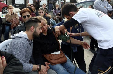 Medics give medical assistance to a relative of a victim outside the medical forensics in Ankara, Turkey, Thursday, Feb. 18, 2016. A Syrian national with links to Syrian Kurdish militia carried out the suicide bombing in Ankara that targeted military personnel and killed at least 28 people, Turkey's prime minister said Thursday. (AP Photo/Burhan Ozbilici)