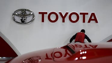An employee works under a Toyota Motor Corp logo at the company's showroom in Tokyo, Japan February 5, 2016. Reuters