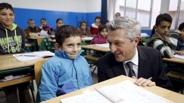 New United Nations High Commissioner for Refugees (UNHCR) Filippo Grandi smiles at a Syrian refugee boy inside a classroom in Beirut, during his visit to Lebanon, January 20, 2016. REUTERS
