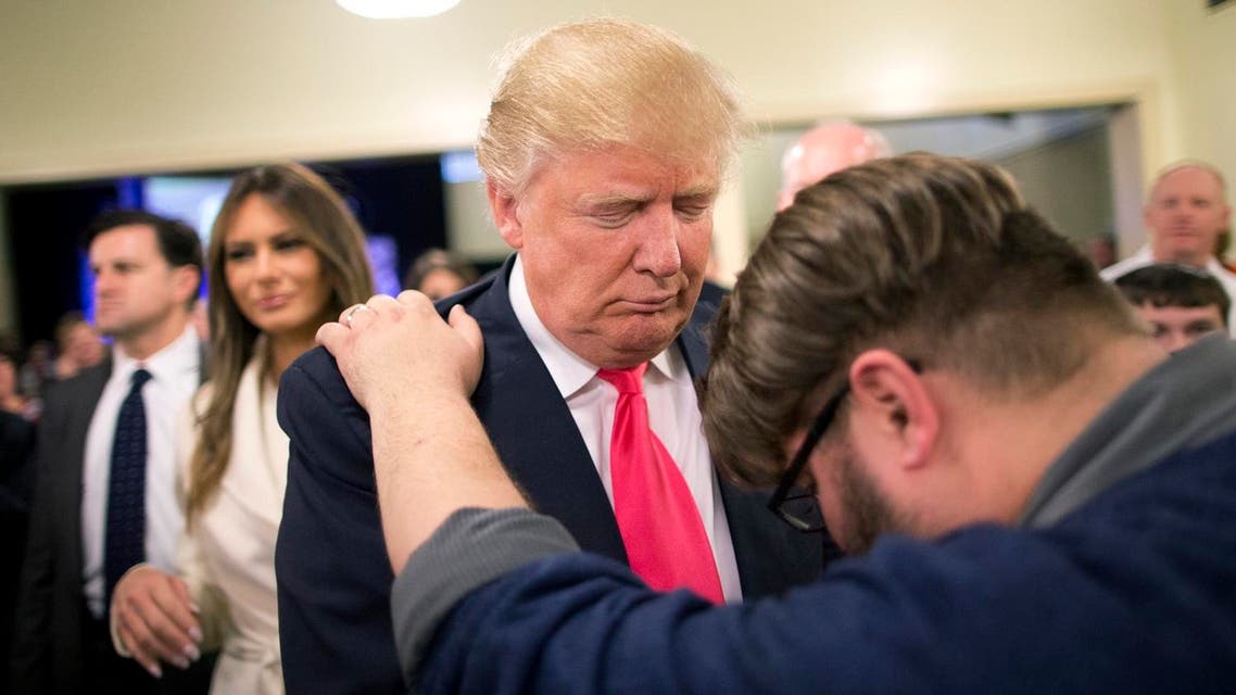 Pastor Joshua Nink, right, prays for Republican presidential candidate Donald Trump, as wife, Melania, left, watches after a Sunday service at First Christian Church. (File photo: AP)