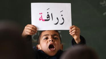In this Thursday, Jan. 21, 2016 photo, a Syrian refugee boy holds up a placard in Arabic, during class at a remedial education center run by Relief International in the Zaatari Refugee Camp, near Mafraq, Jordan. (AP) 