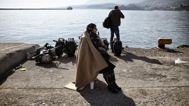 A migrant woman waits at the port of Mytilene, on the Greek island of Lesbos, after crossing the Aegean sea from Turkey. (AFP)