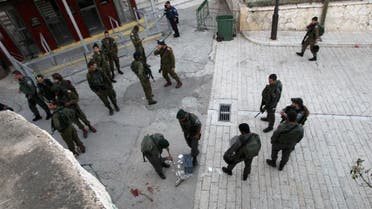 Israeli security forces clean the pavement at the site where a Palestinian was shot dead after stabbing a border policeman on April 25 2015 near the Tomb of Patriarchs in the West Bank city of Hebron. AFP, Hazem Bader (AFP)