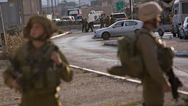 Israeli soldiers stand at the scene of a stabbing attack, at the Hawara checkpoint near of the West Bank city of Nablus, Monday, Nov. 23, 2015. The Israeli military said a Palestinian was shot dead as he tried to stab a soldier at the checkpoint. (AP Photo/Majdi Mohammed)