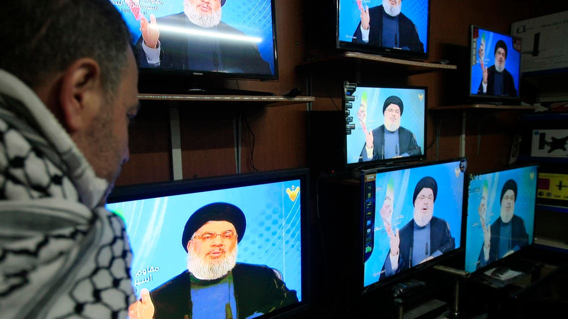 A Lebanese man watches Hezbollah leader Sheik Hassan Nasrallah give a speech through the window of an electronic shop, in the southern port city of Sidon, Lebanon, Monday, Dec. 21, 2015. (AP)