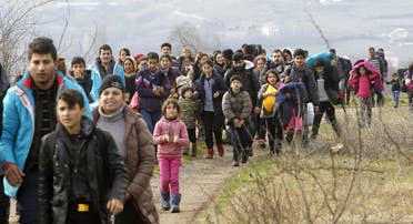 Refugees and migrants, mostly from Afghanistan, walk towards the transit center for refugees near the northern Macedonian village of Tabanovce, after being returned from Serbia, Monday, Feb. 22, 2016.