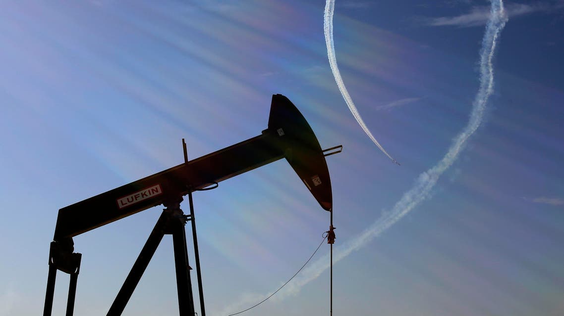 In this Saturday, Jan. 23, 2016, file photo, an oil pump stands as the Saudi Hawks Aerobatic Team of the Royal Saudi Air Force performs during the Bahrain International Airshow in Sakhir, Bahrain. (AP)