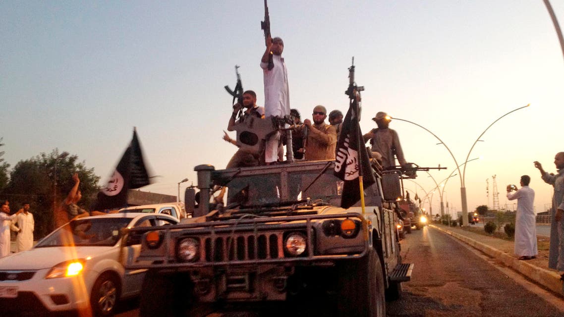 In this photo taken Monday, June 23, 2014, fighters from the Islamic State group parade in a commandeered Iraqi security forces armored vehicle down a main road at the northern city of Mosul, Iraq. AP