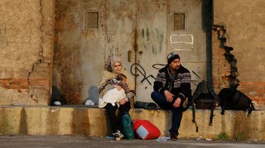 A family sits after the arrival of refugees and migrants from the eastern Greek islands to the Athens' port of Piraeus, Friday, Feb. 26, 2016. AP