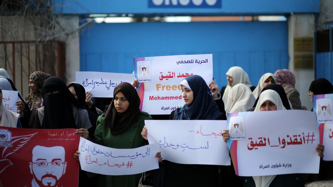 Palestinian women hold posters bearing a portrait of Palestinian hunger striking Palestinian journalist Mohammed al-Qiq, who is imprisoned in an Israeli jail, on February 21, 2016. (AFP)