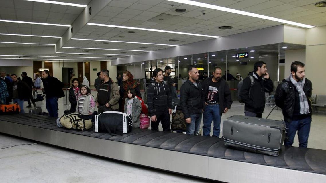 Iraqi refugees returning from Finland wait for their luggage at Baghdad airport, Iraq February 18, 2016 (Reuters)