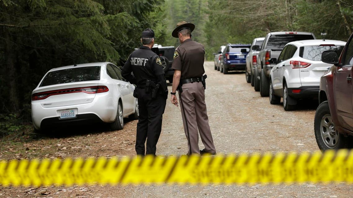 Mason County Sheriff's Chief Criminal Deputies Russ Osterhout, left, and Ryan Spurling, right, stand on a road near the scene of a fatal shooting Friday, Feb. 26, 2016, near Belfair, Wash. AP