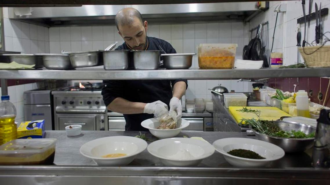 In this photo taken on Saturday Feb. 20, 2016, Palestinian chef Jihad al-Maharmeh prepares a mixed Palestinian French dish, Freekeh lamb rack at Orjuwan restaurant in the West Bank city of Ramallah. At a time of simmering Mideast tensions and rising malaise, a group of French chefs recently visited the West Bank to bring a little joie de vivre to Palestinian kitchens.(AP Photo/Nasser Nasser)