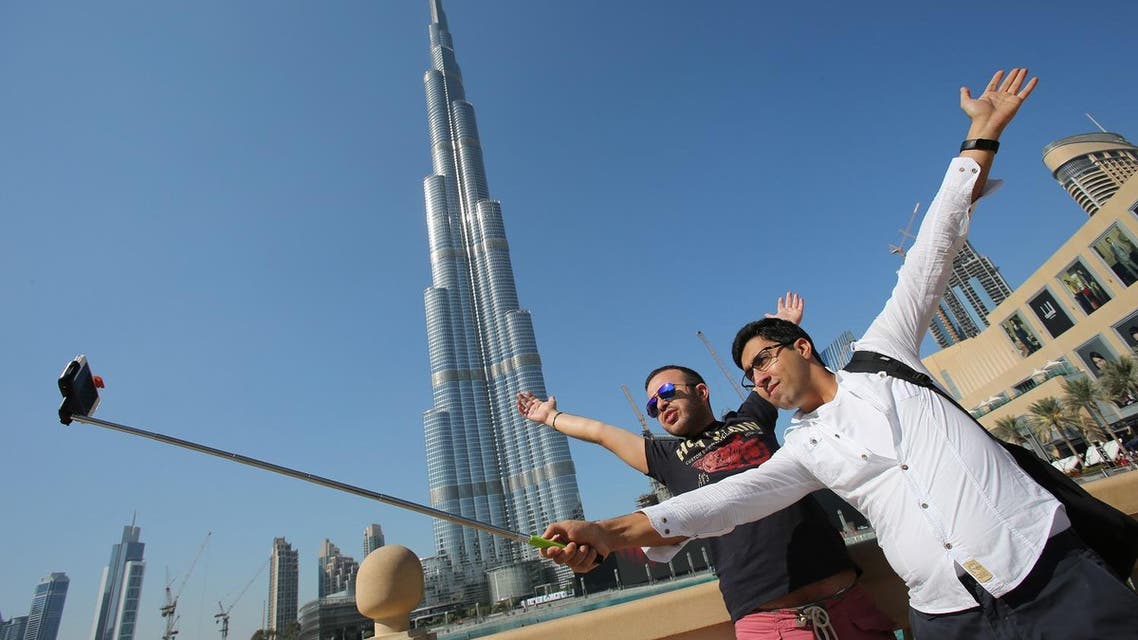 In this Tuesday, Jan. 6, 2015 photo, Rasul Alekberov holds a selfie stick next to his friend Gudrat Aghayev both tourists from Republic of Azerbaijan while they take a selfie in front of "Burj Khalifa". (AP)