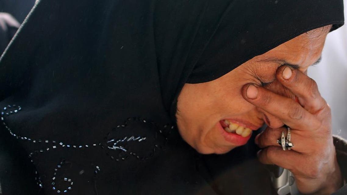 In this Feb. 24, 2014 file photo released by the United Nations Relief and Works Agency for Palestine Refugees in the Near East (UNRWA), a resident of the besieged Palestinian camp of Yarmouk weeps as she waits to receive humanitarian aid from UNRWA in Damascus, Syria. Over the past two years, the ability of humanitarian groups to deliver aid to Syrians has become increasingly difficult. (UNRWA via AP, File)