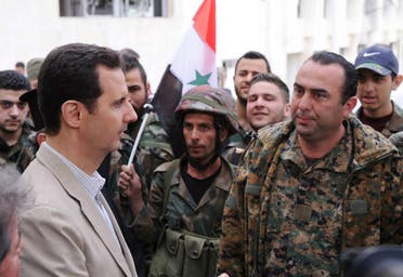 In this file photo taken on Sunday April 20, 2014 and released by the Syrian official news agency SANA, Syrian President Bashar Assad, left, talks to government soldiers during his visit to the Christian village of Maaloula, near Damascus, Syria. (SANA via AP, File)