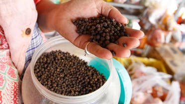 In this Tuesday, March 1, 2016 photo, a vendor holds a handful of Kampot pepper before selling at a market in Phnom Penh, Cambodia, Tuesday, March 1, 2016. Cambodia's Kampot pepper has joined an elite group of gourmet food items whose names are protected by the European Union. The EU said Tuesday that Kampot pepper was officially registered as having Protected Geographical Indication status, or PGI, on Feb. 18, making it the first Cambodian product to receive the label. (AP Photo/Heng Sinith)