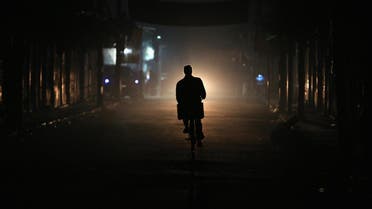 A resident drives a motorbike at night on New Year's Eve in eastern al-Ghouta. (Reuters)
