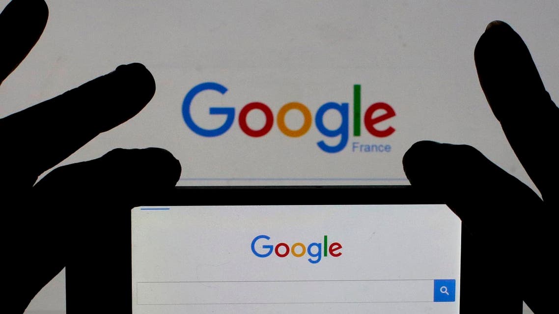A woman holds her smart phone which displays the Google home page. (Reuters)