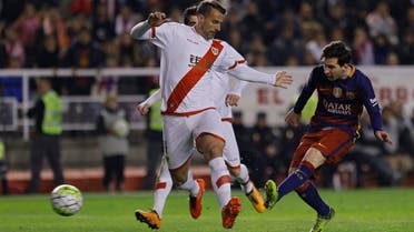 Barcelona's Lionel Messi, right scores past Rayo Vallecano's Antonio Amaya, left, his side's fourth goal during a Spanish La Liga soccer match between Barcelona and Rayo Vallecano at the Vallecas stadium in Madrid, Thursday, March 3, 2016. Messi scored a hat trick in Barcelona's 5-1 victory. (AP)