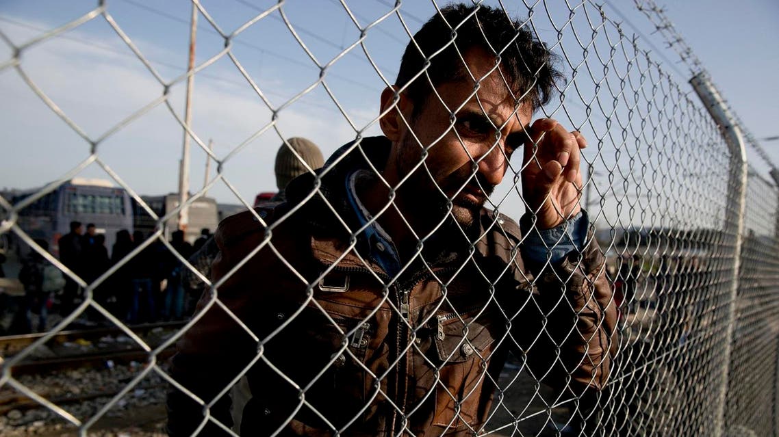 An Afghan migrant waits behind a fence to board a bus in the northern Greek border station of Idomeni. (File photo: AP)