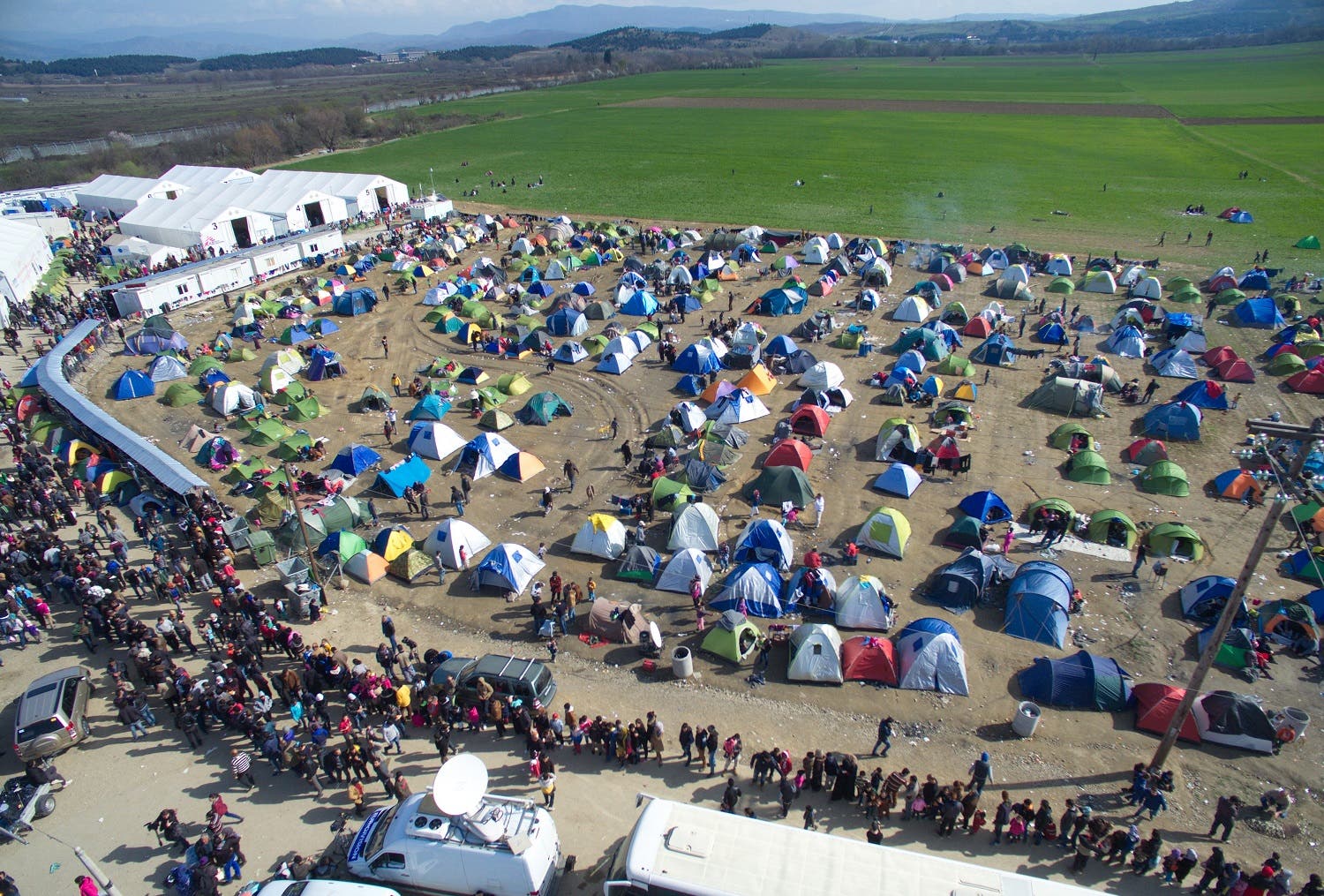 Refugees and migrants wait in queue to receive food distributed by non-governmental organization at a refugee camp at the Greek-Macedonian border, near the northern Greek village of Idomeni, Thursday, March 3, 2016. (AP)