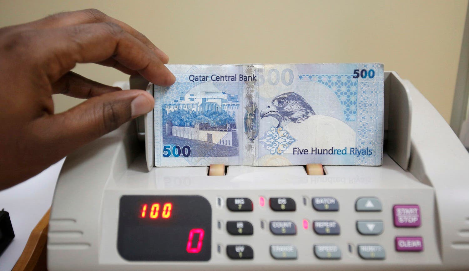 A cashier counts Qatari riyal notes at a money changer in Doha May 28, 2013. (Reuters)