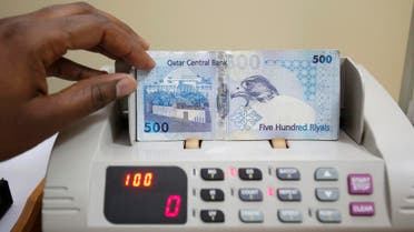 A cashier counts Qatari riyal notes at a money changer in Doha May 28, 2013. (Reuters)