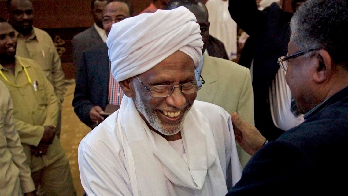 In this Monday, Jan. 27, 2014 photo, Sudanese religious and Islamist political leader Dr. Hassan al-Turabi, center, is greeted as he attends a speech by Sudanese President Omar al-Bashir in Khartoum. AP