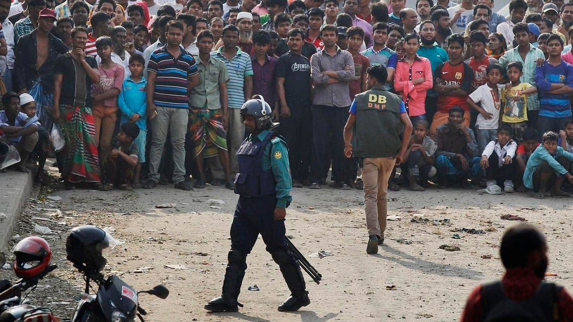 This Saturday, Feb. 20, 2016 photo shows local residents watching a police raid on a building in Dhaka, Bangladesh, Saturday, Feb. 20, 2016. Bangladesh police said they arrested two suspected members of a banned radical Islamist group and seized at least 20 bombs and bomb-making materials in a series of raids over the weekend. Authorities have been under pressure to crack down on radical groups after attacks on foreigners and minorities last year raised concern about rising extremism in the secular South Asian nation. Police have given confusing statements about Saturday's raids and what was found. (AP Photo)