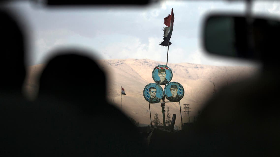 Portraits of Syrian President Bashar Assad, bottom right, Syrian general, President's Assad brother, Maher Assad, bottom left, and former Syrian President Hafez Assad, are placed at a check point on a road north of Damascus, Syria, Thursday, March 3, 2016. (AP