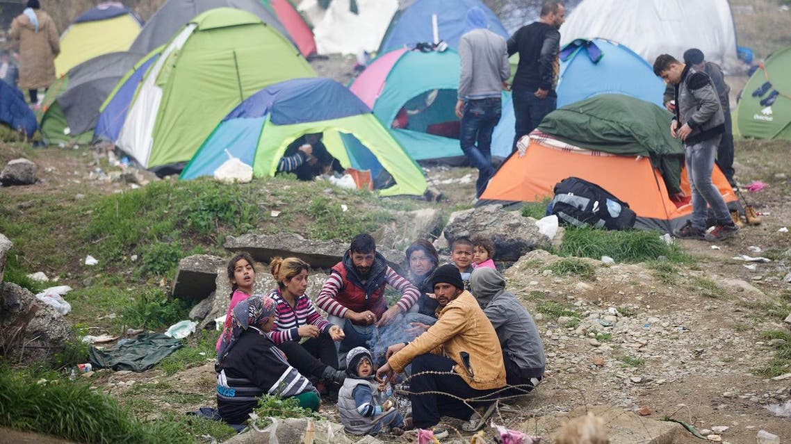 A migrant family gather around a fire, at the northern Greek border station of Idomeni, Monday, March 7, 2016 (Photo: AP)